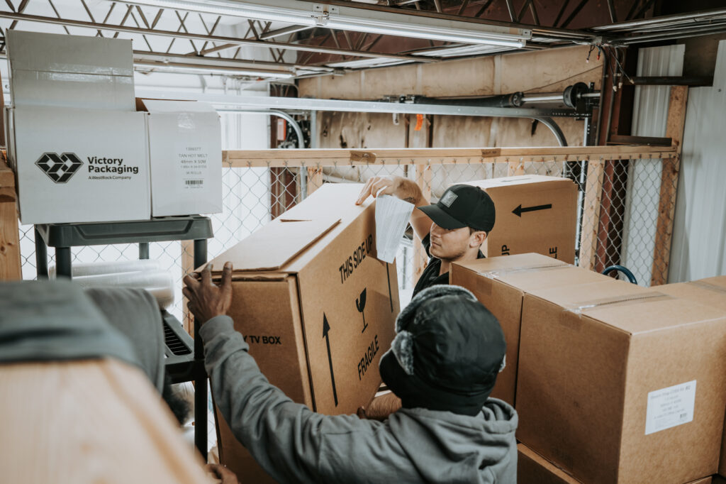 Two Wolf Moving employees moving a box of fragile items