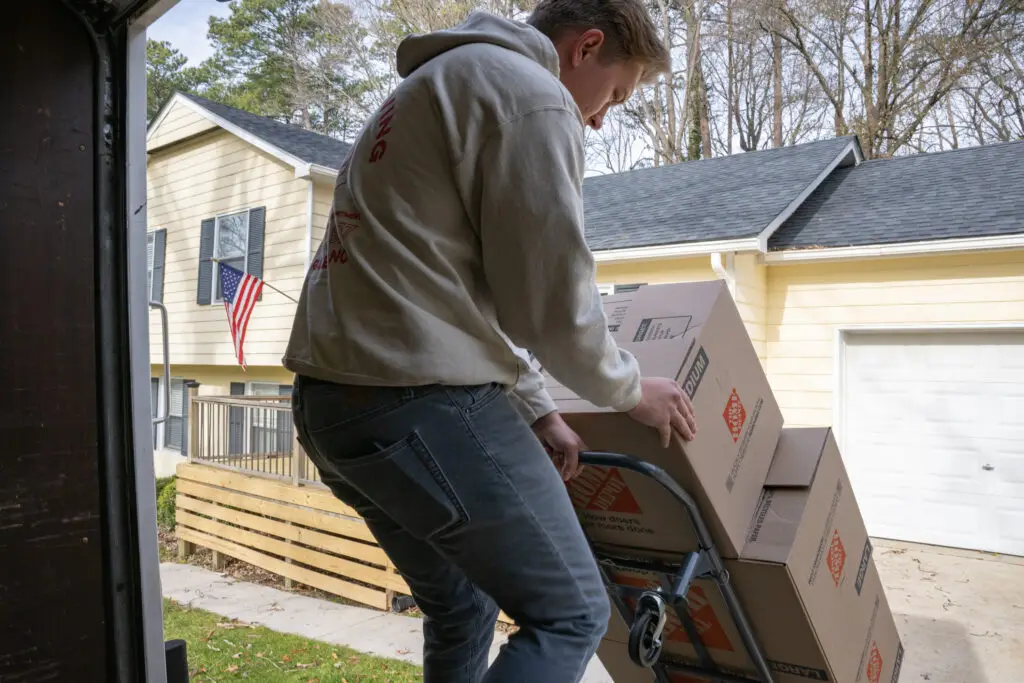 Close up of a wolf moving employee bringing boxes on to the moving truck