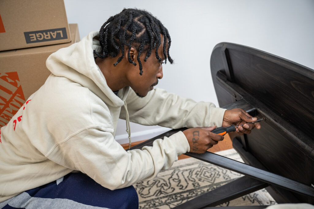 wolf moving employee disassembling a piece of furniture to be packed