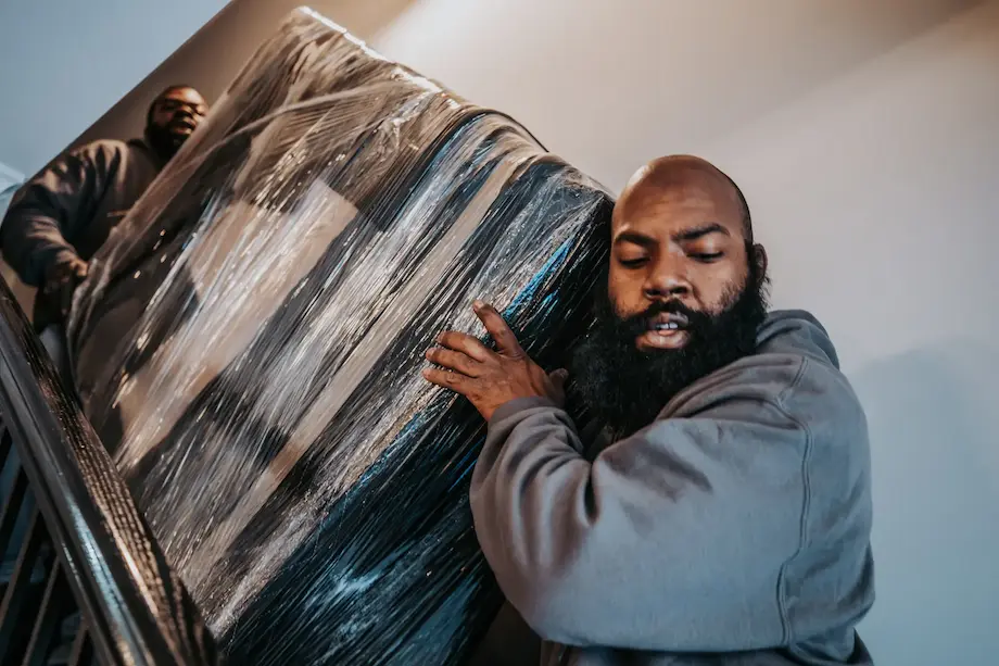 movers carrying wrapped mattress down stairs in raleigh nc